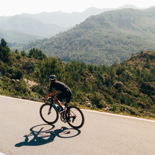 Rennradfahrer fährt auf Gebirgsstraße